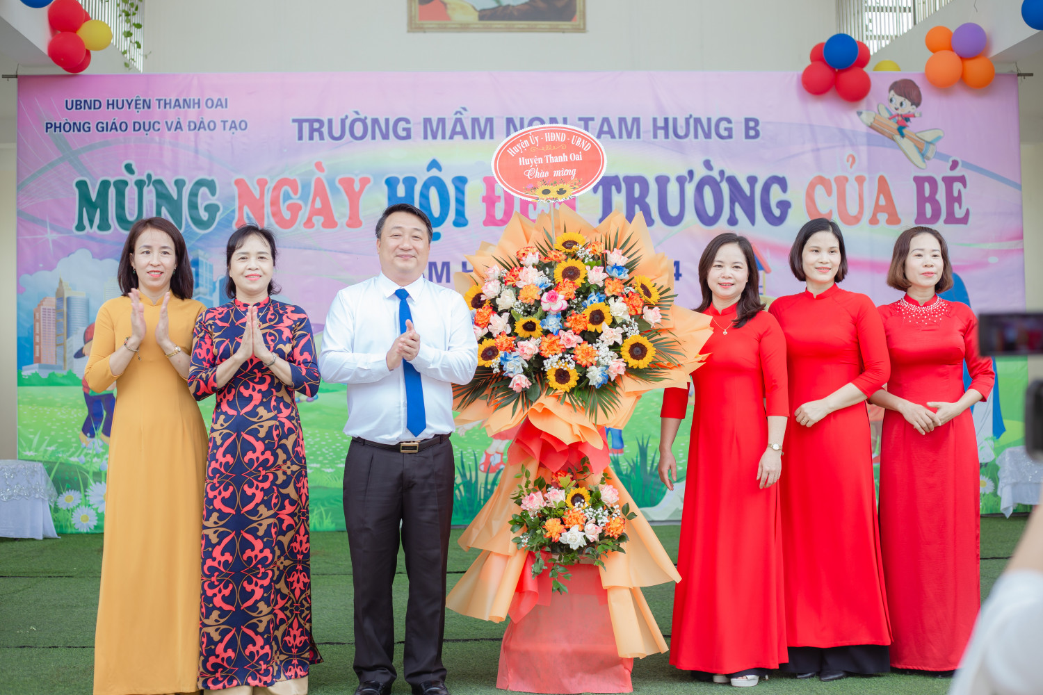 Ông Nguyễn Khánh Bình - Huyện Ủy Viên, Phó Chủ tịch UBND huyện lên tặng hoa chúc mừng.